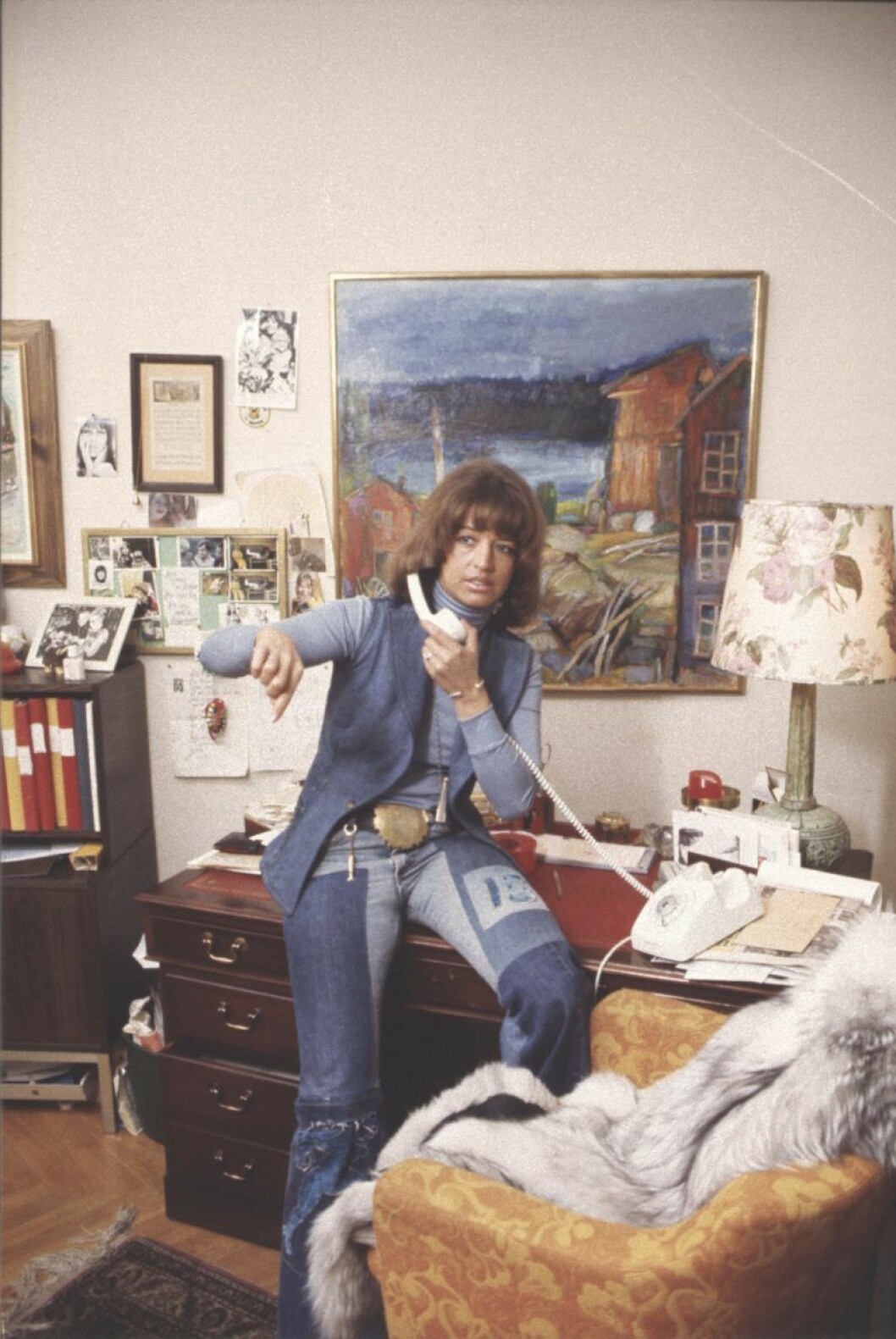 I double denim 1975. Lill-Babs helt klädd i denim sitter på en skrivbord med en telefon mot örat.