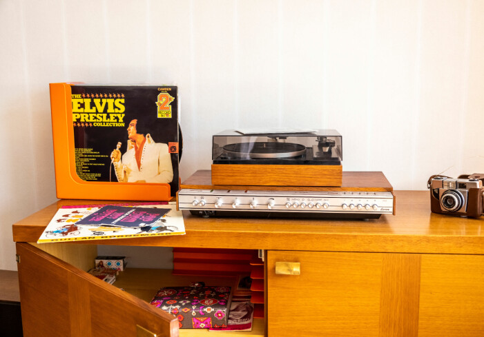 I dag är det många som plockar fram sina grammofonspelare igen eftersom man uppskattar närvaron i ljudet. Skåp från 70-talet med grammofonspelare, en gammal skiva med Elvis Presley och en gammal analog kamera.