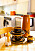 Detaljbild på ett köksbord med detaljer typiska från 70-talet. En orange kaffetermos, en brun kaffeservis och en sockerströare med orange plast.
