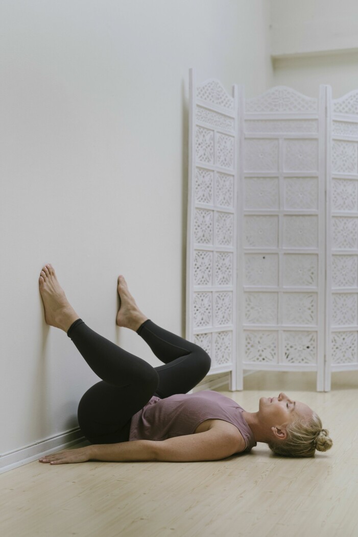 Åsa Nyvall visar yinyoga: Huksittande mot vägg