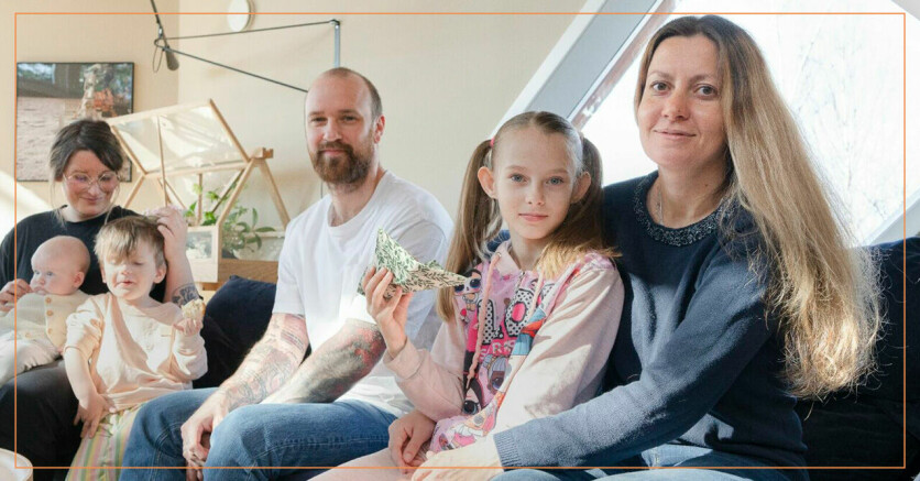 En mamma från Ukraina med sin dotter tillsammans med en svensk familj i en soffa.