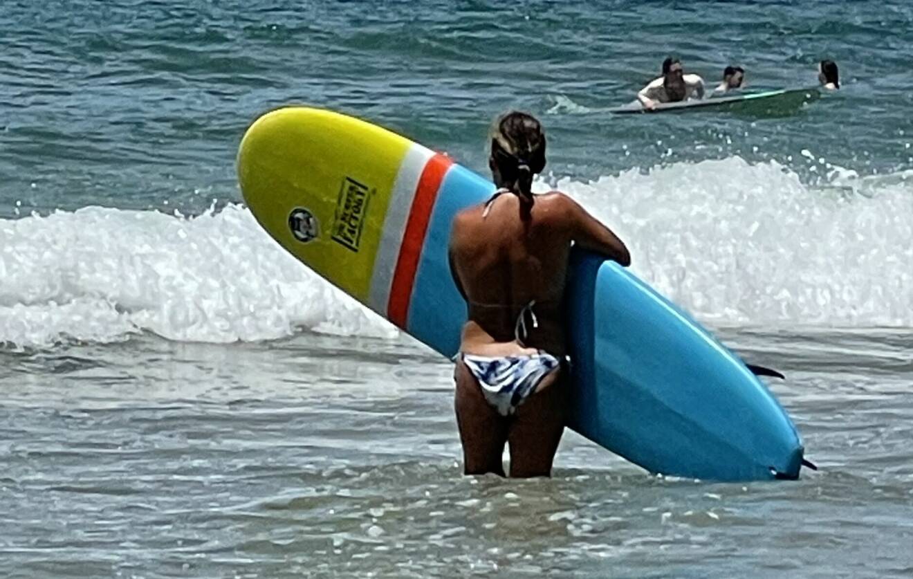 Annette Forslund står i vattnet med en surfingbräda