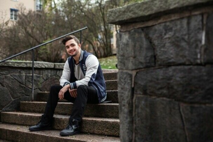 Idag är Anthony kvitt sina ätstörningar. Foto: SVT/Pia Letho. Anthony yigit idag sitter på en trappa och ler