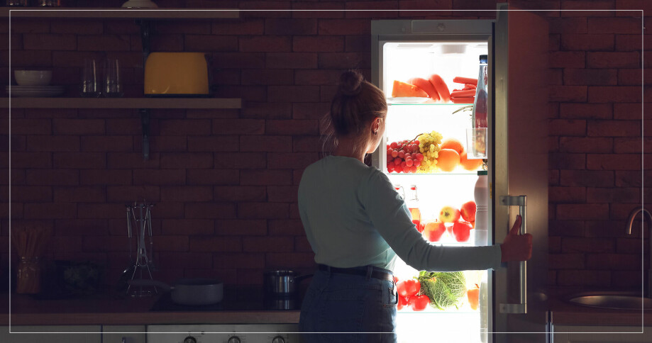 Kvinna tittar in i kylskåpet