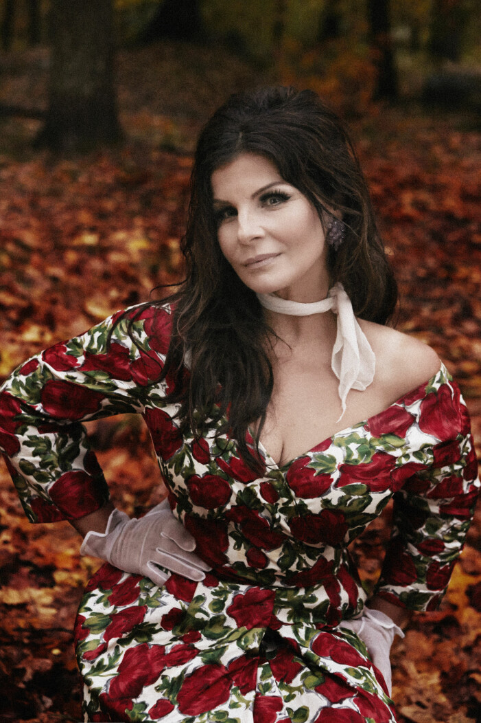 Carola i rödblommig klänning bland höstlöv