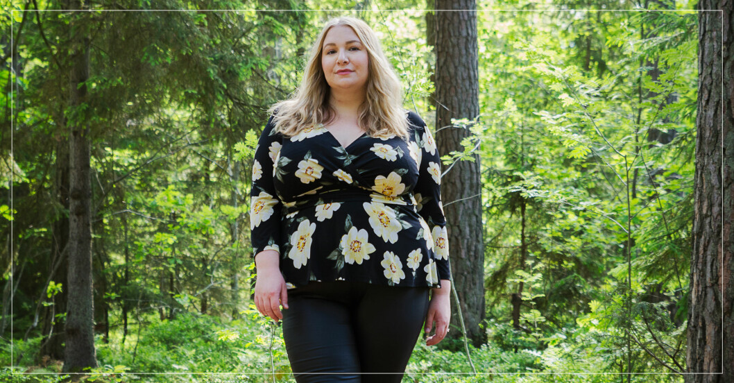 Ung blond kvinna i grönskande skog