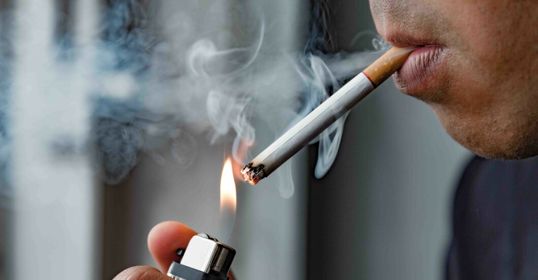 Man som tänder en cigarett.