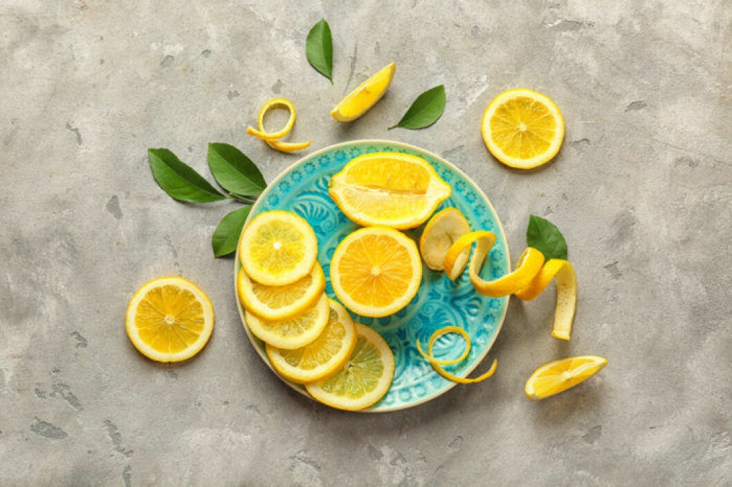 Bild: Shutterstock/IBL Skivade och delade citroner på ett blått fat. Vid sidan av fatet ligger även några gröna blad.