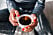 Kvinna med röda naglar håller i en kaffekopp