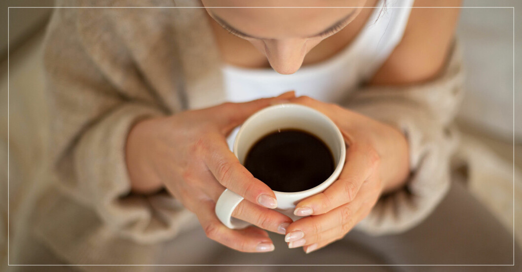 Kvinna med en kopp svart kaffe i händerna
