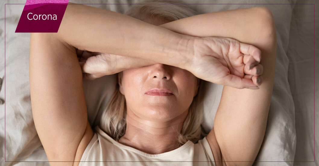 Kvinna ligger i säng med armarna i kors framför ögonen eftersom hon är utmattad