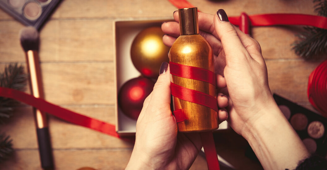 Kvinna får en flaska parfym i julklapp