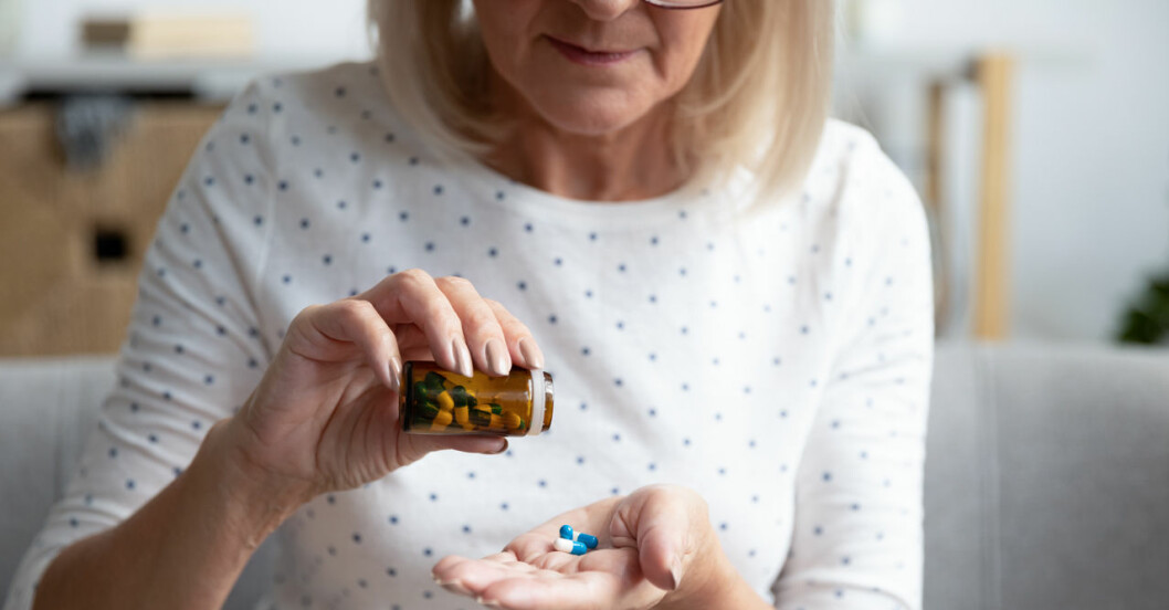 Kvinna häller ut tabletter i sin hand