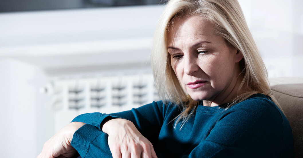 Kvinna som lider av depression sitter i sin säng
