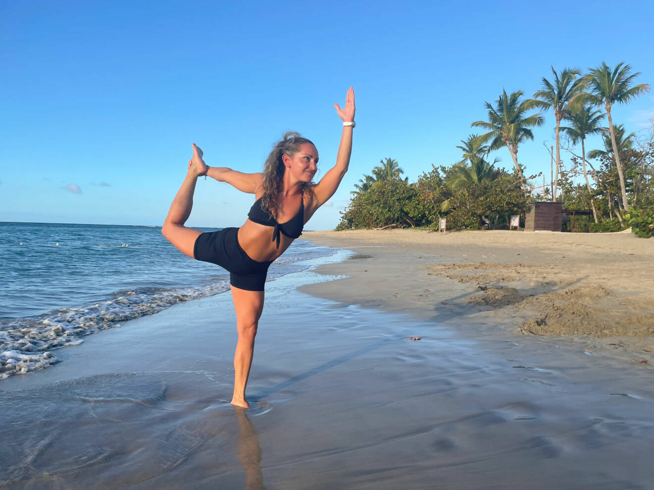 Kvinna gör yoga på stranden i Dominikanska republiken