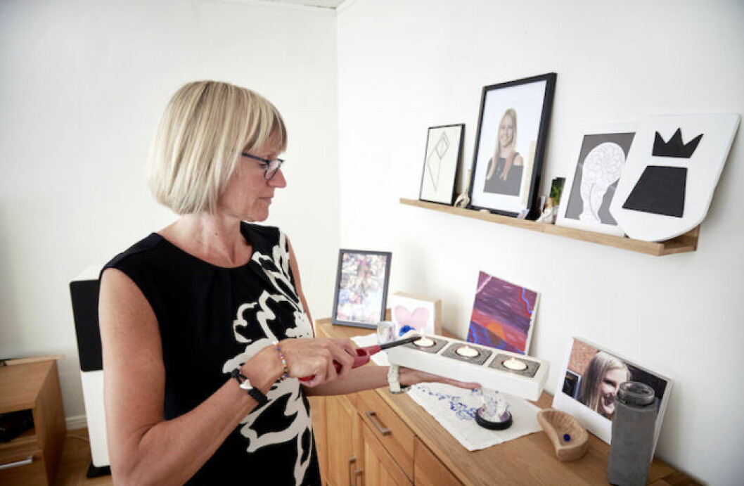 Maria tänder ljus vid minnesväggen av Fanny i hemmet.