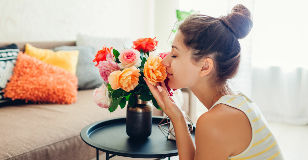 kvinna blir glad och får energi av att dofta på blommor