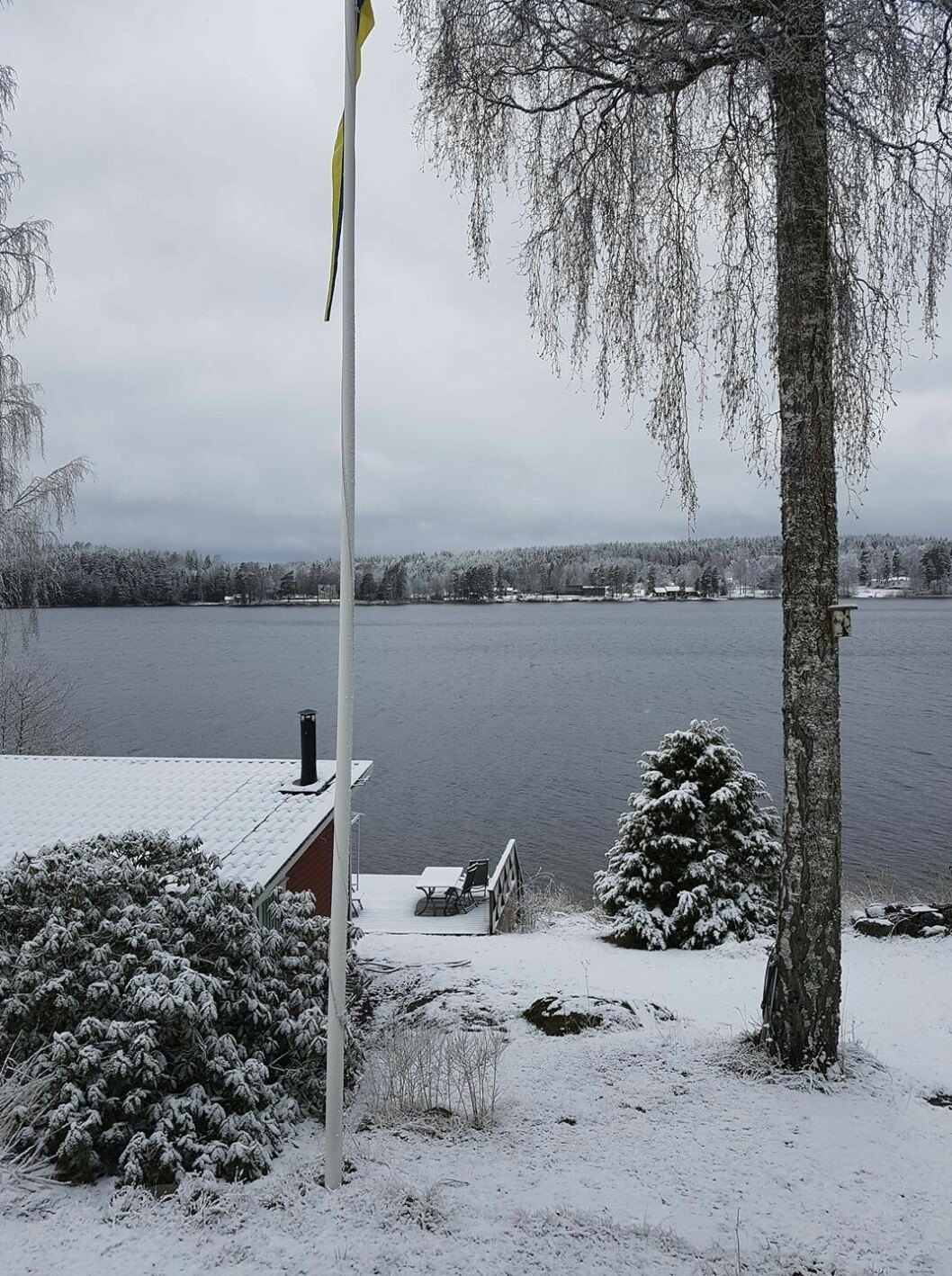 Stugan i Värmland i vinterskrud. Hit var det meningen att paret skulle flytta så småningom. Parets lantställe i snö och frost, med utsikt över vatten.