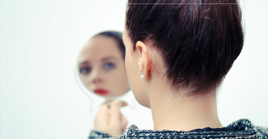 Kvinna som tittar sig i spegeln.