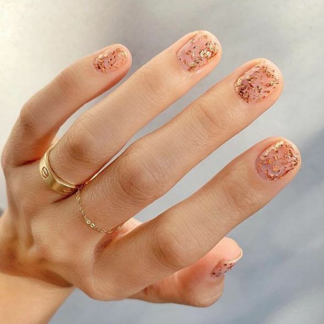 En bild på en nagelmanikyr i guldglitter. 
