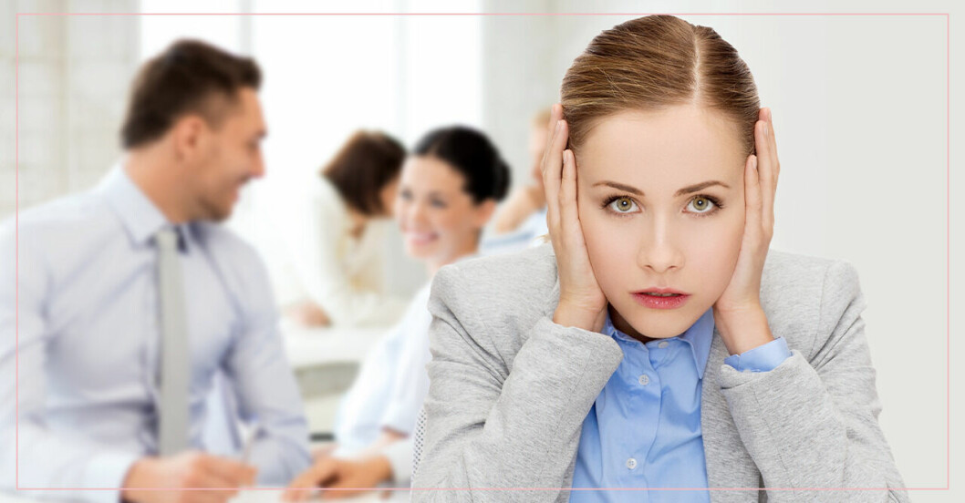 kvinna stressad på jobbet när folk pratar runtomkring