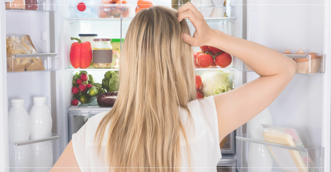 hungrig kvinna letar mat i kylskåpet