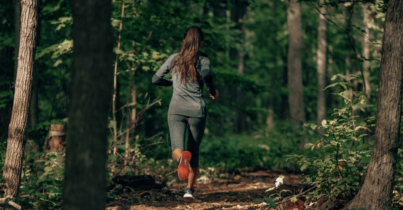 Kvinna springer i skog