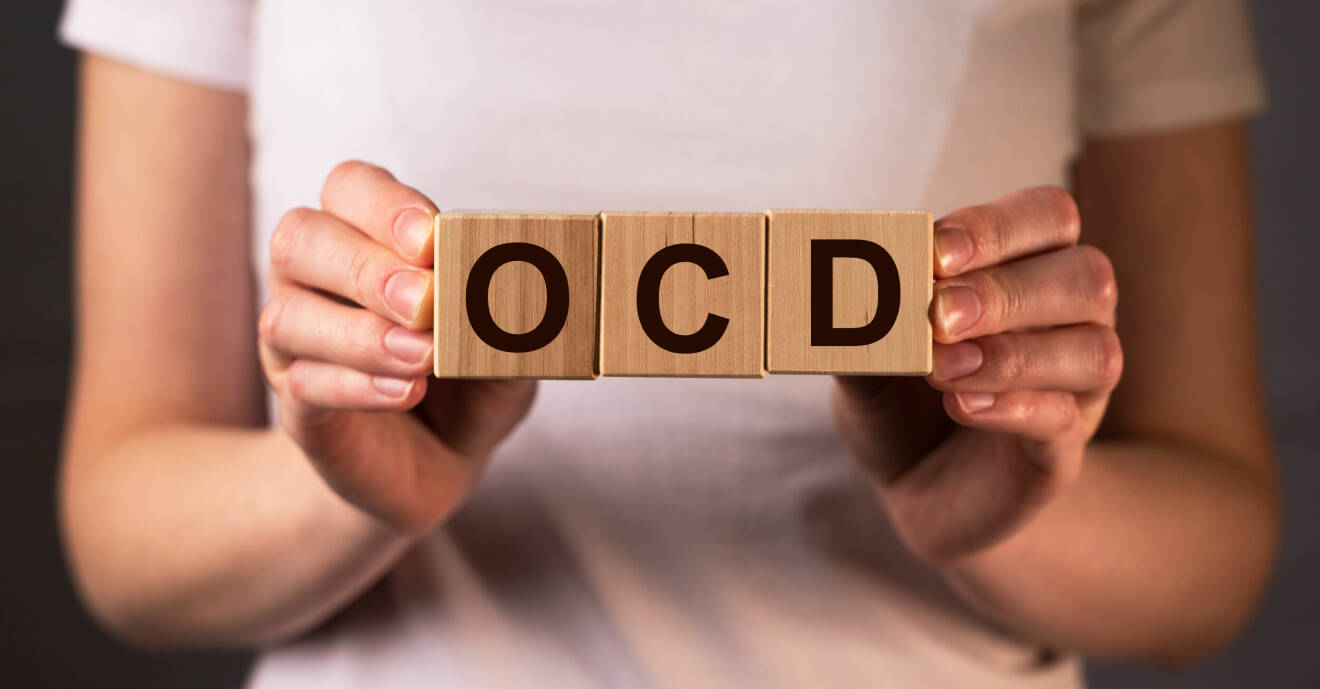 En kvinna håller upp klossar med bokstäverna OCD