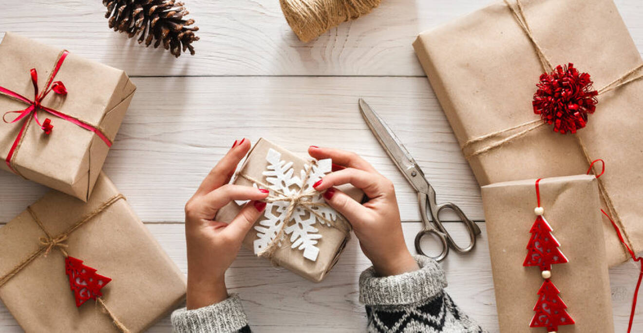Woman's hands wrapping christmas holiday present with craft twine
