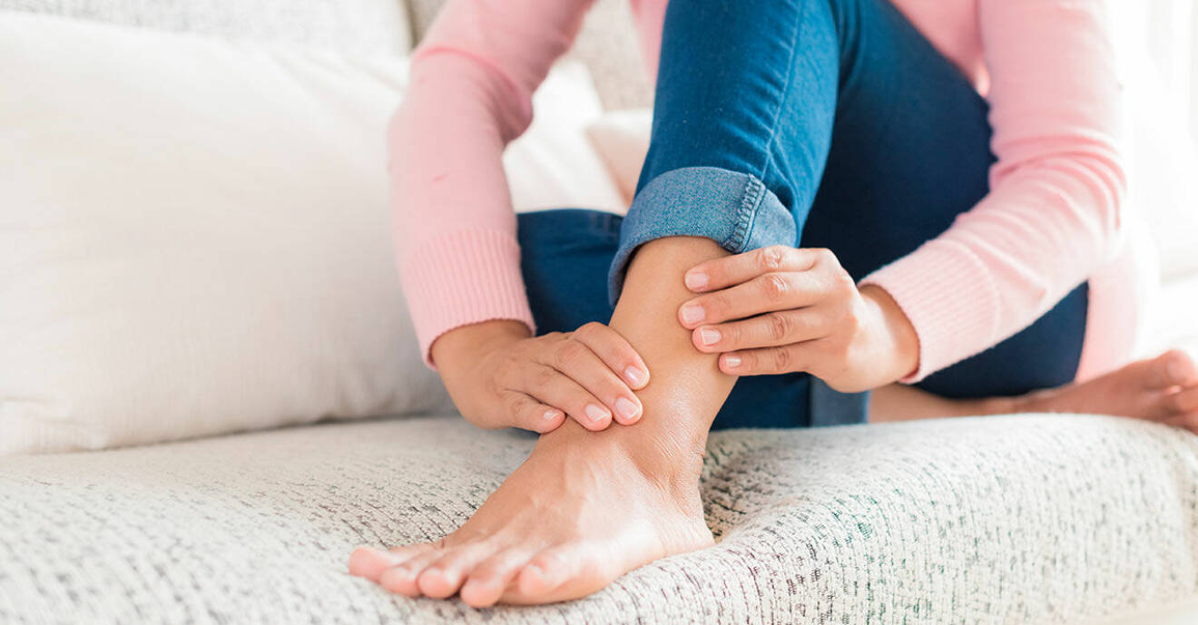 Kvinna som har ont i benen och masserar sin vad vid restless legs-syndrome