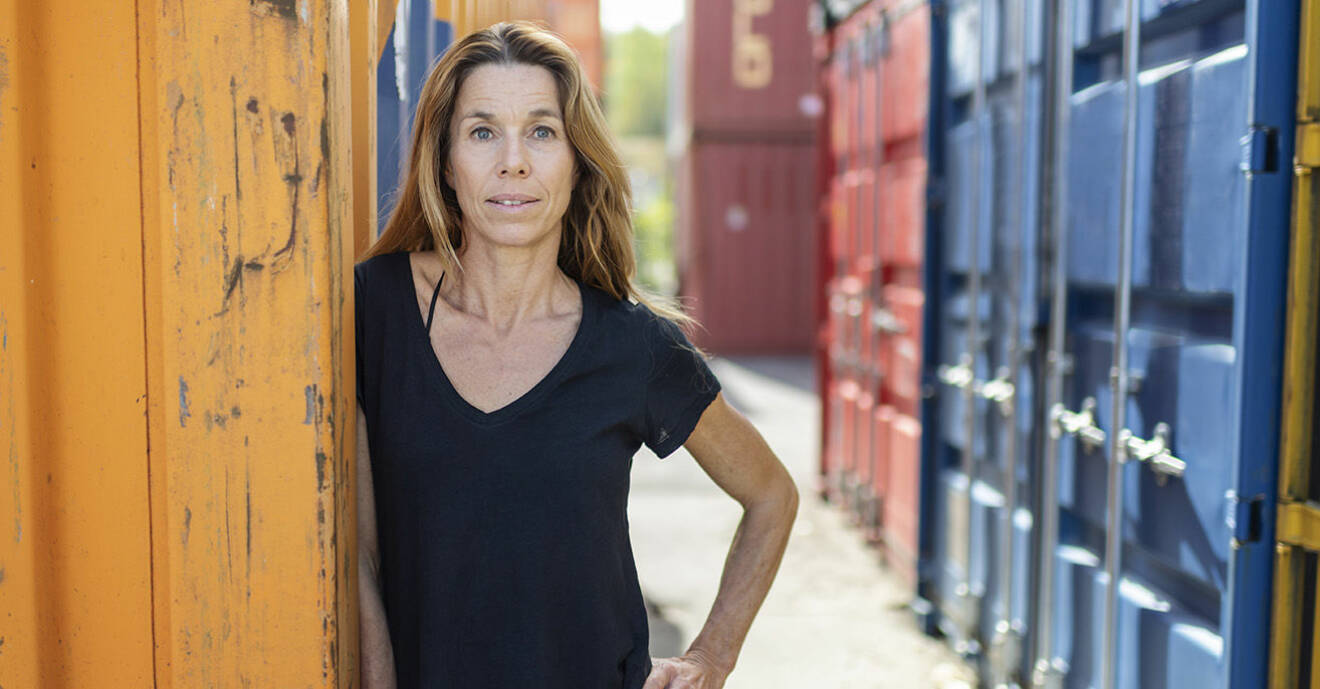 Magdalena Forsberg står bland containrar och ser allvarlig ut