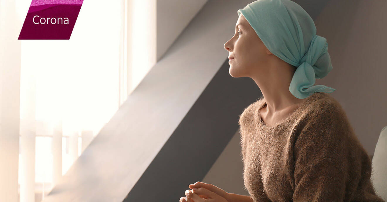 kvinna med cancer tittar ut genom fönstret.
