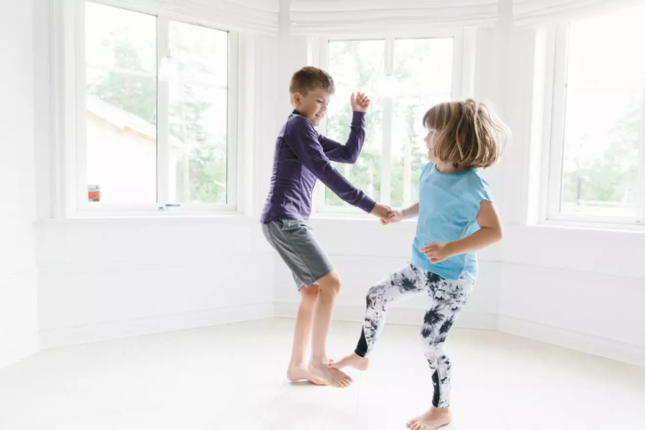 Två barn som tränar balans tillsammans. 