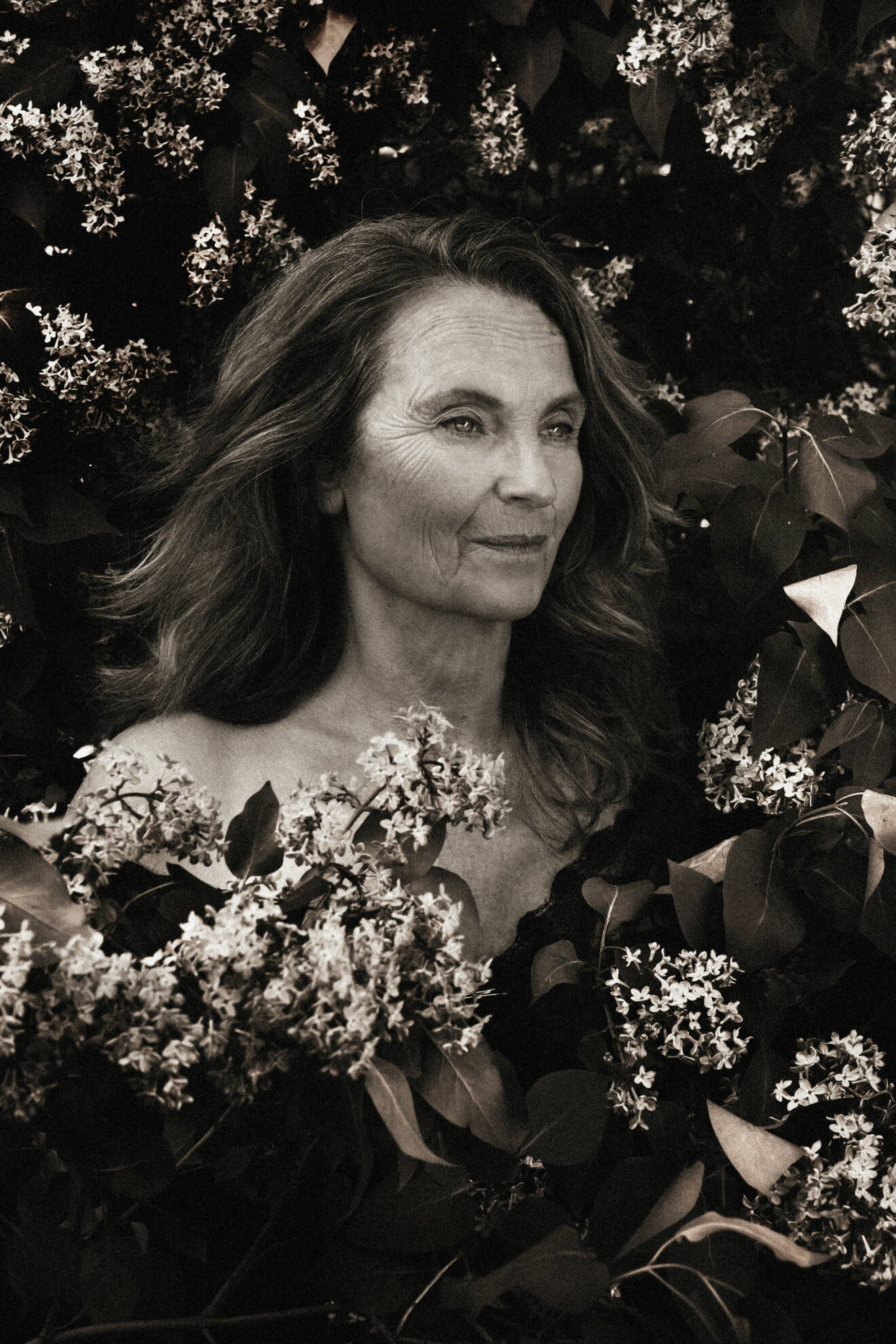 Suzanne Reuter naken bland blommor, svartvitt