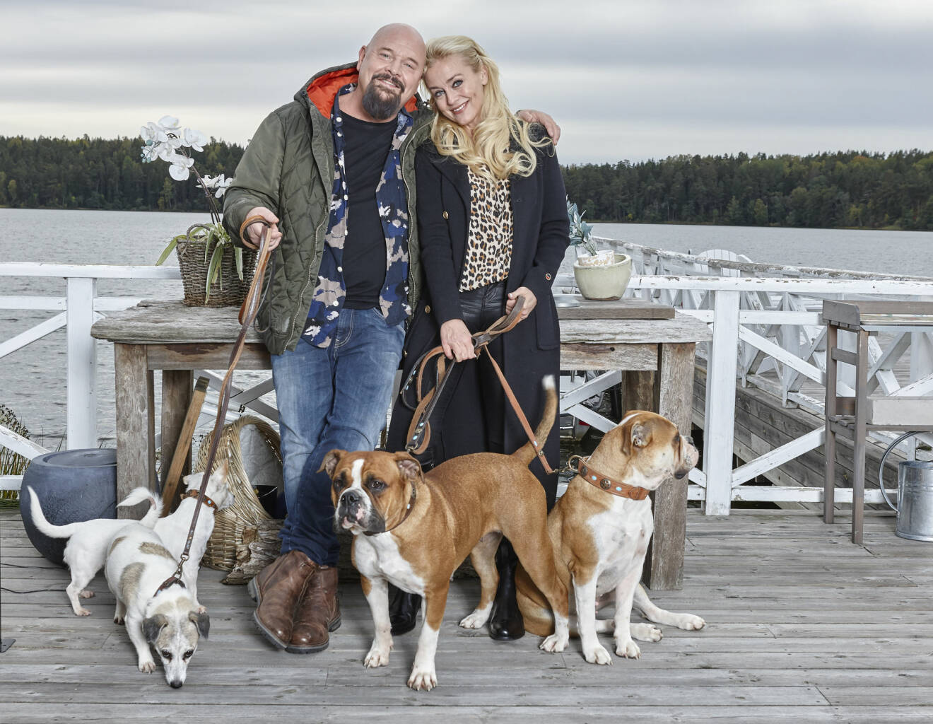Anders Bagge och Johanna Lind Bagge med fyra av sina hundar på en brygga.