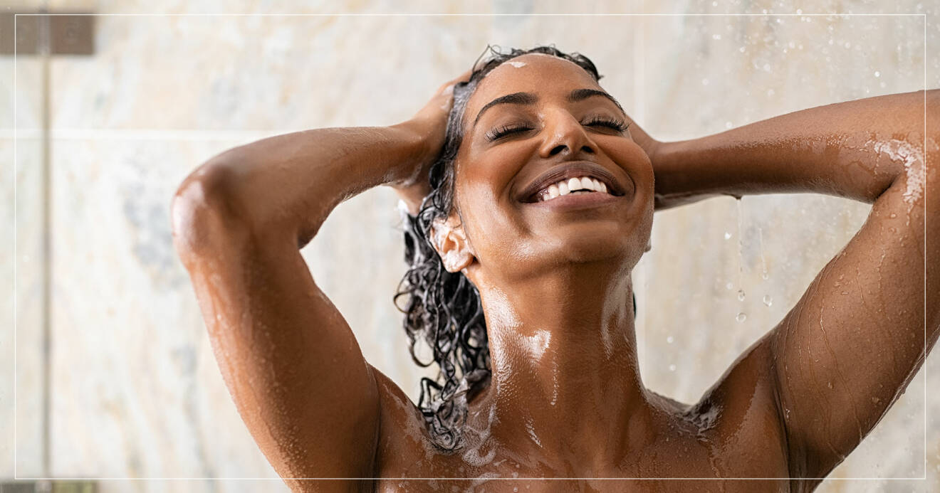 Kvinna ler samtidigt som hon tvättar håret