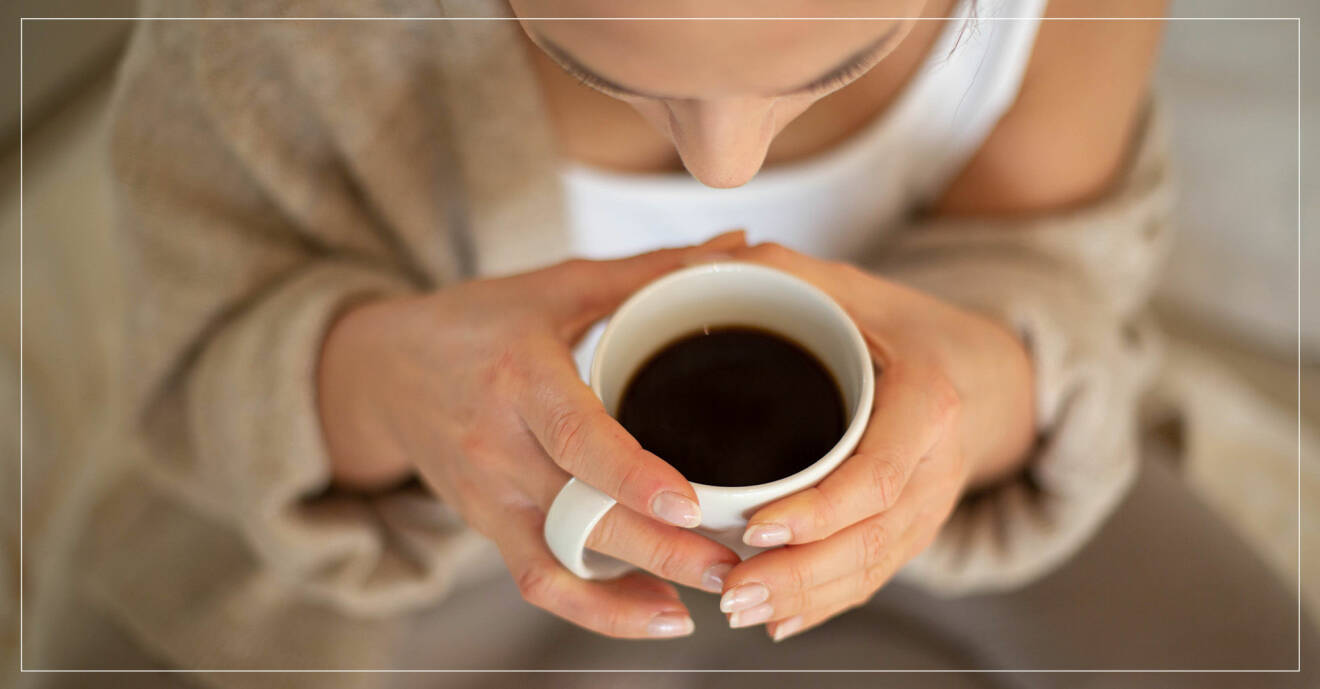 Kvinna med en kopp svart kaffe i händerna