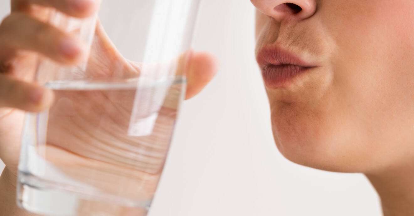 Kvinna dricker vatten, för att undvika att bli vrålhungrig av träning
