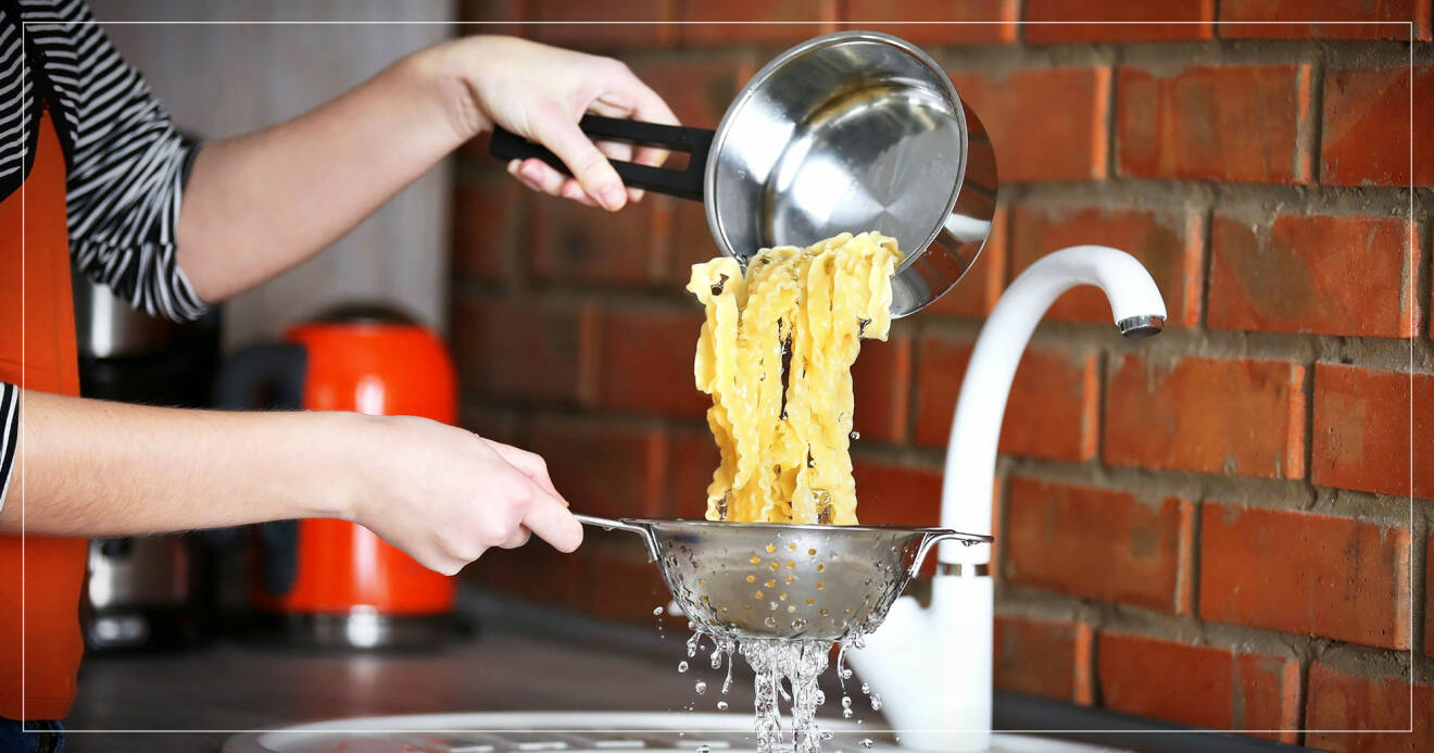 Person häller pasta från kastrull till durkslag