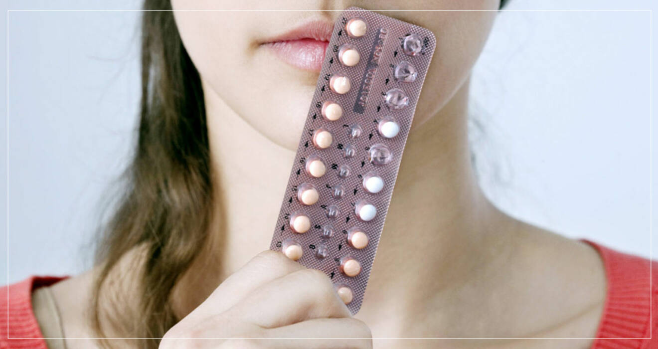 kvinna håller p-pillerkarta framför munnen.