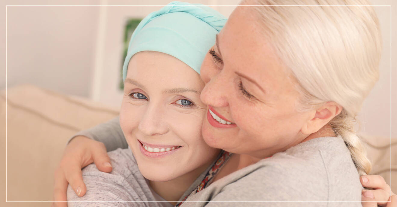 cancersjuk kvinna i turban får en kram av väninna