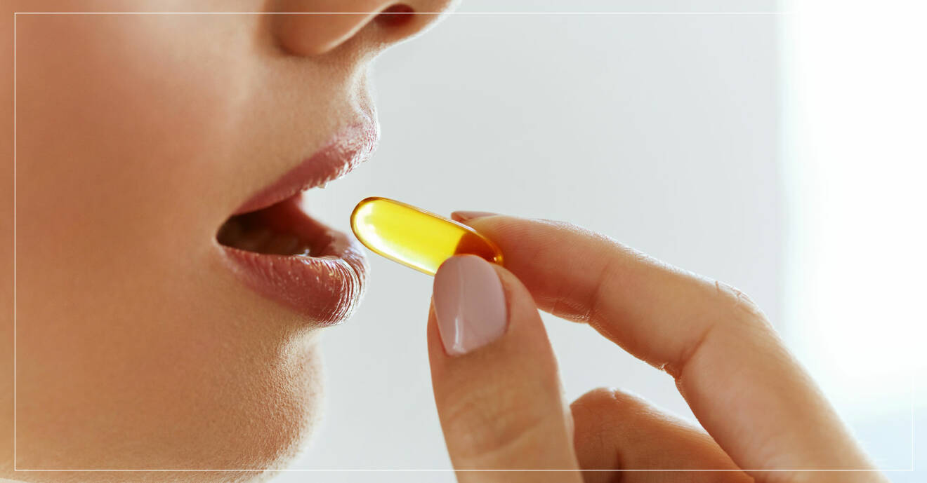 kvinna stoppar vitaminpiller i munnen