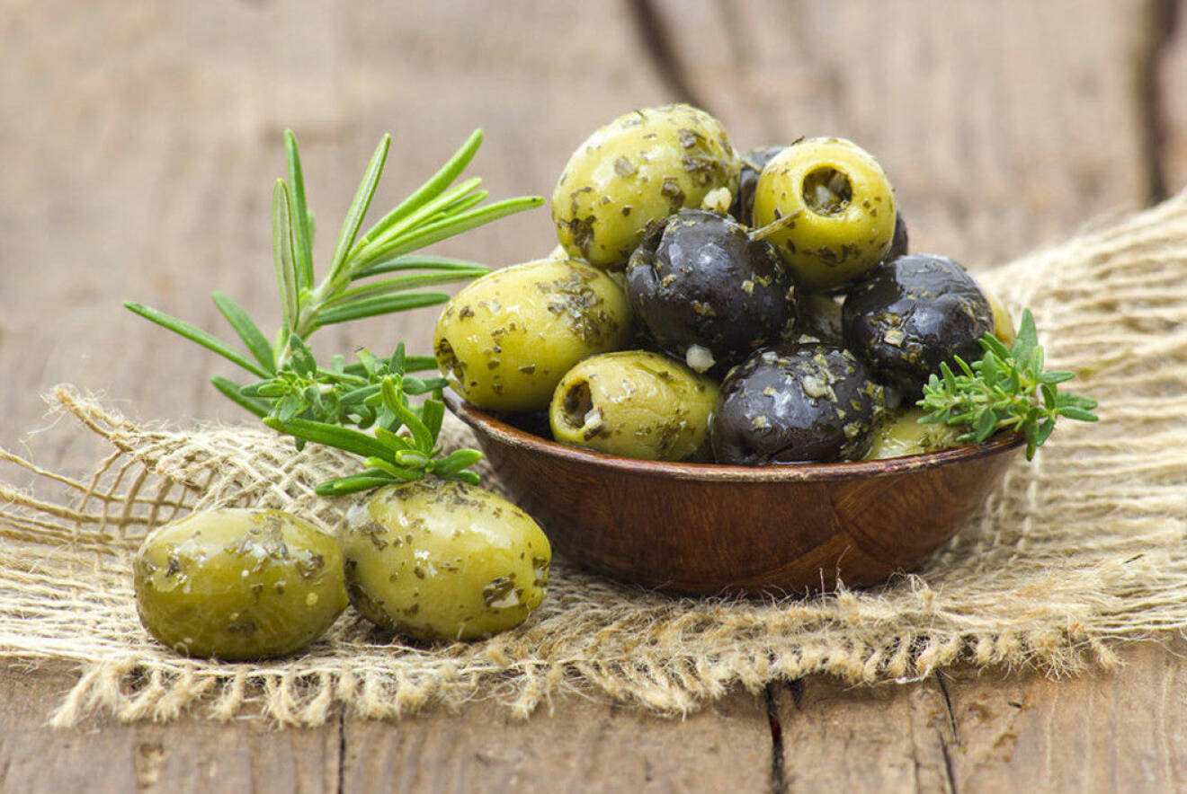 Gröna och svarta oliver i en skål.