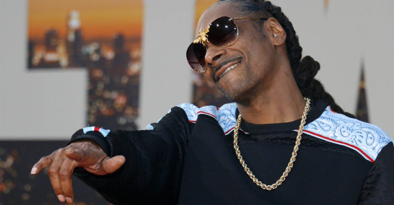 Snoop Dogg har på sig solglasögon och gör en pose framför kameran