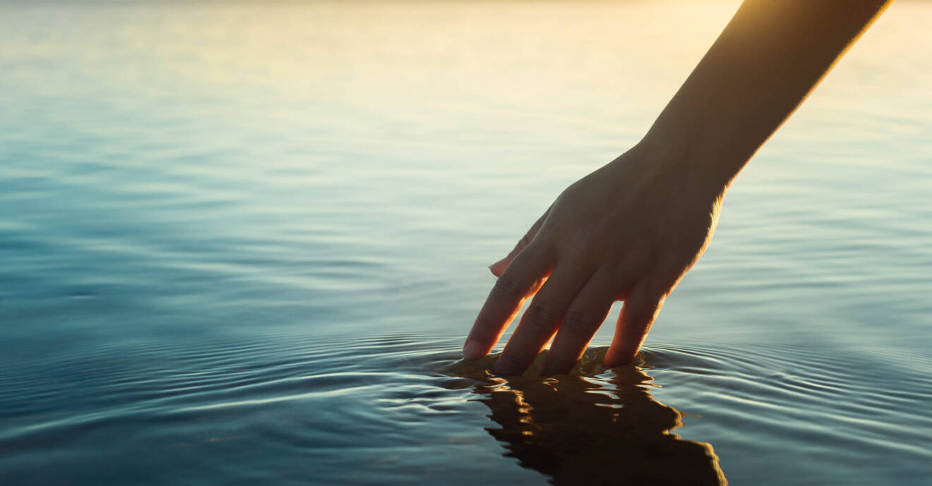 kvinna stressar ner genom att stryka sin hand genom vatten