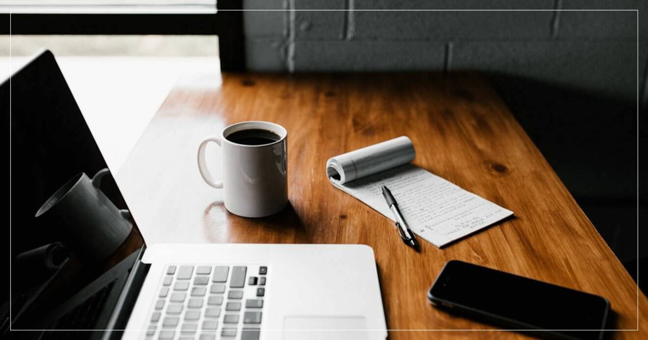 Skrivbord med laptop, kaffe och en att göra-lista