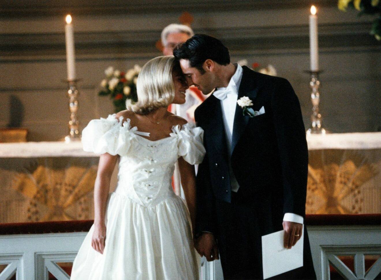 Pernilla Wahlgren och Emilio Ingrosso vid parets bröllop 1993. Pernilla bär en vit klänning med stora puffärmar och kysser Emilio på bilden.