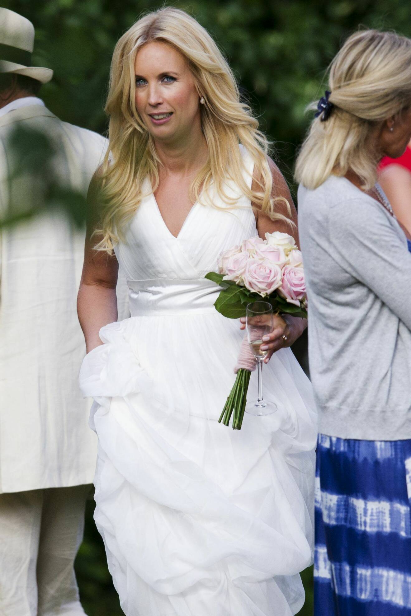Jenny Strömstedt vid sitt bröllop 2011. Här i en vit klänning, brudbukett med vita och rosa rosor och utsläppt hår.