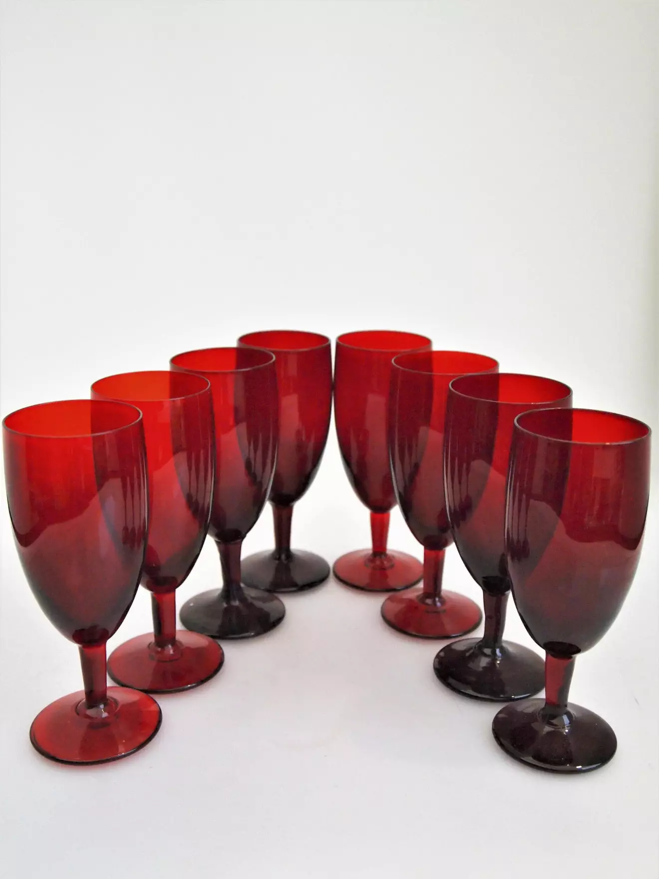 Monica Bratt började på Reijmyre glasbruk 1937 och blev kvar där i drygt 20år. Hon byggde upp en helt egen kollektion och gjorde stora insatser för bruket. De rubinröda glasen är bland hennes mest kända skapelser. Höjden är 15cm. 450kr för åtta glas på Lysekils Auktionsbyrå.