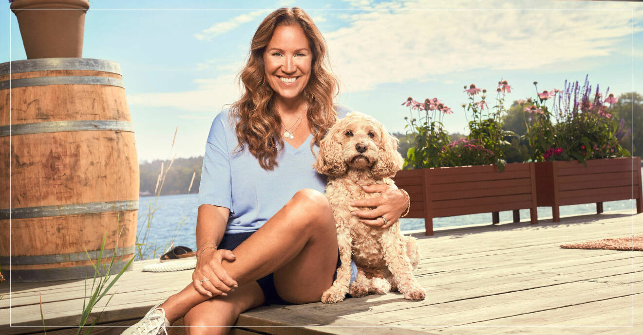 Renee Nyberg med hunden Charlie på bryggan där kändisarna gästar varje sommar